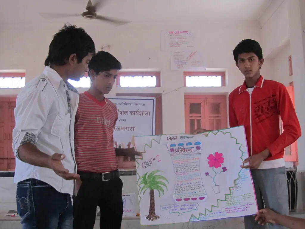 Young men presenting a hand-drawn poster